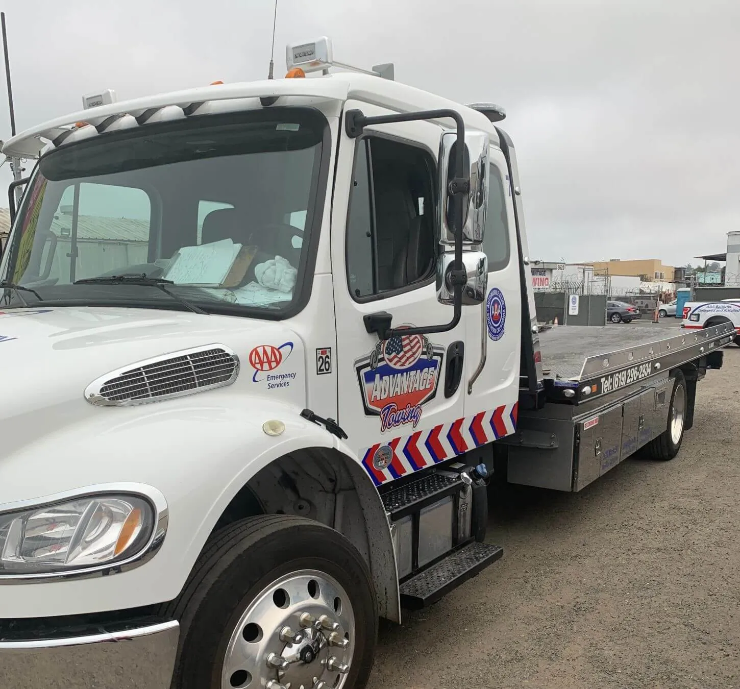 Front three-quarter view of an Advantage Towing rollback carrier with chevron livery