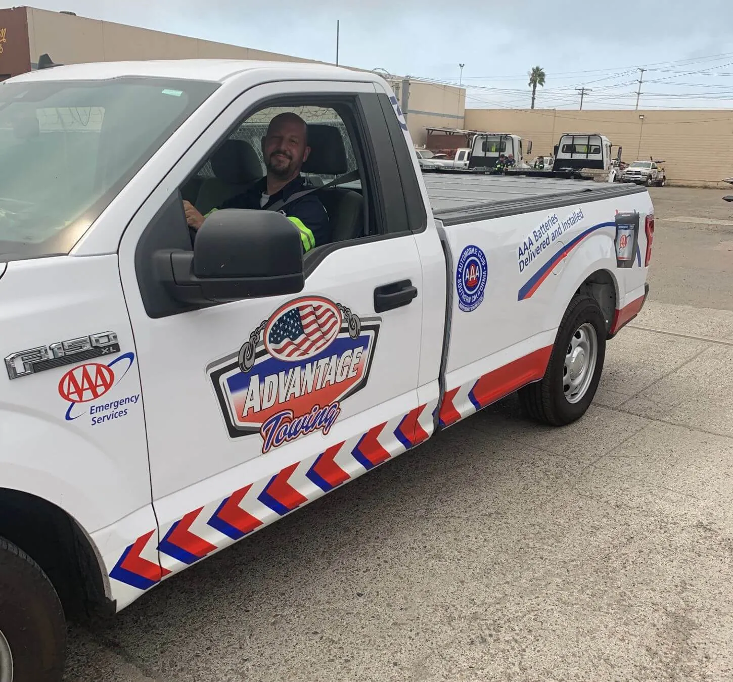 Advantage Towing roadside pickup in chevron livery with an operator at the wheel