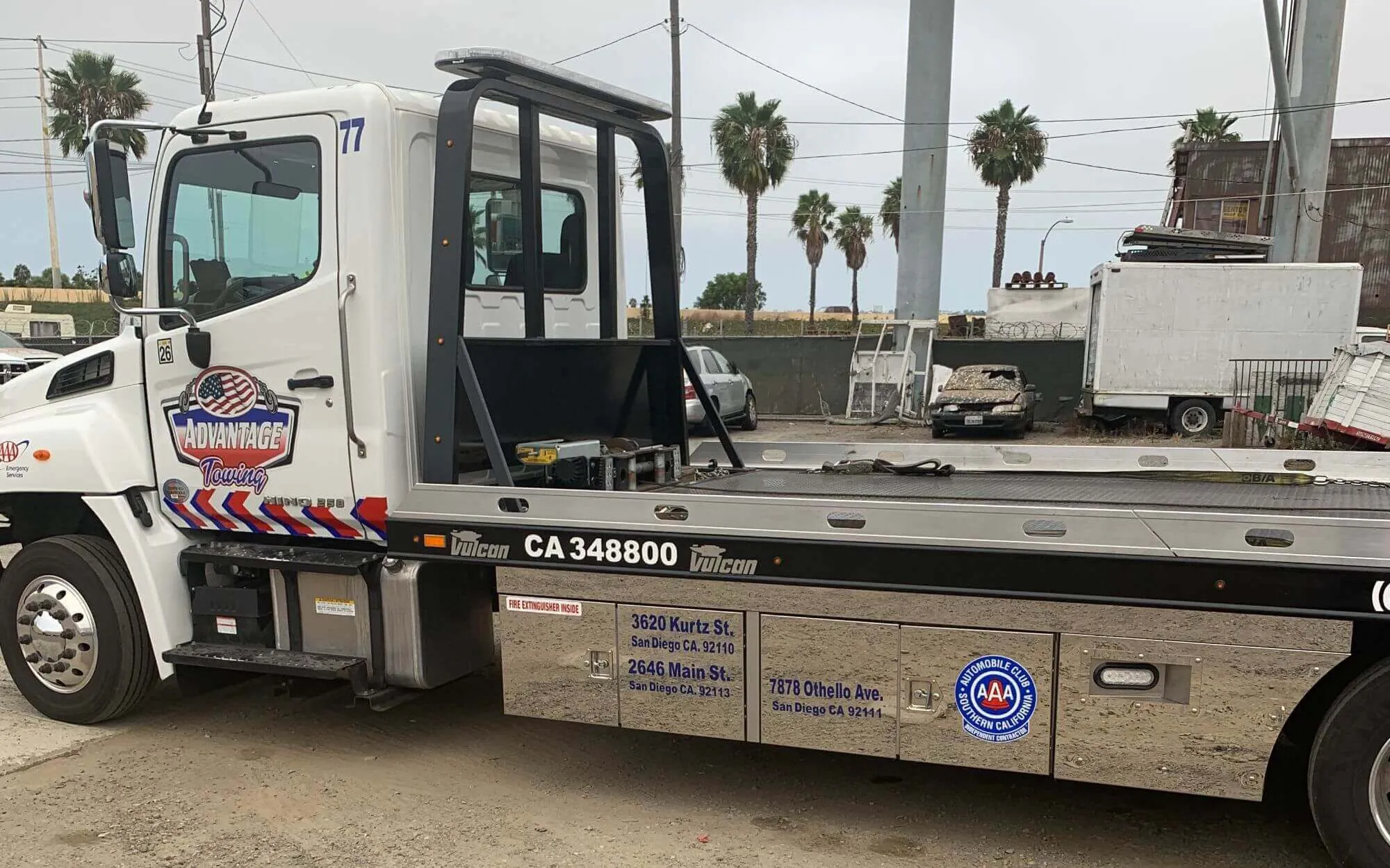 Rollback flatbed carrier, unit 77, with CA 348800 on the bed