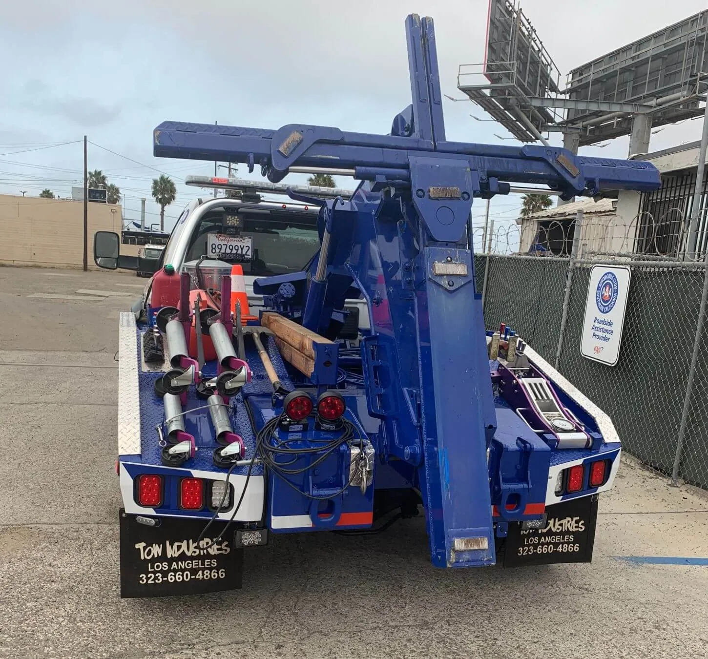 The blue boom and wheel-lift on the back of a wrecker